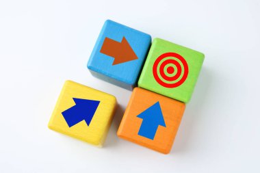 Hedef alınıyor. Beyaz arkaplanda hedef tahtası olan yeşili gösteren oklu renkli küpler, üst görünüm