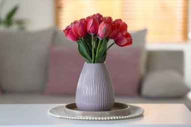 Beyaz masadaki vazodaki güzel laleler