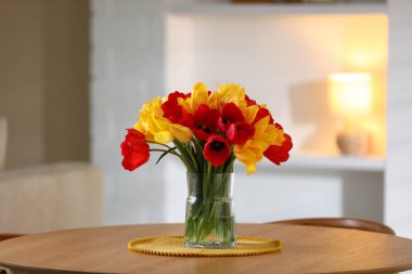 İçerideki ahşap masada vazodaki güzel laleler.