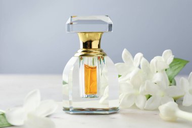 Parfüm ve yasemin çiçekleri gri arka planda, yakın plan