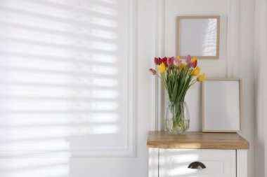 Güzel lalelerden oluşan bir buket ve kapalı bir masada ahşap bir çerçeve. Metin için boşluk