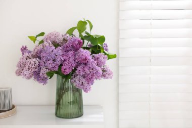 İçerideki masada vazoda güzel leylak çiçekleri, metin için boşluk.