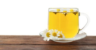 Cam fincanda nefis papatya çayı ve beyaz arka planda tahta masada taze çiçekler.