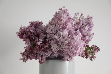 Beyaz masanın yanındaki vazoda güzel leylak çiçekleri.