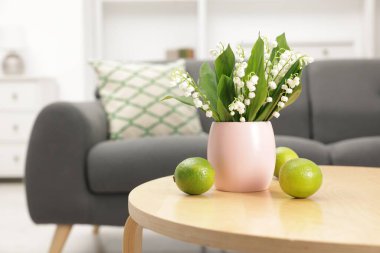 Bir buket güzel vadi zambağı ve kahve masasında limon. Metin için boşluk