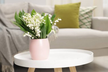 Bir buket güzel vadi zambağı kahve masasının üstünde.