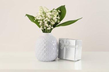 Vadi çiçeklerinin güzel zambakları ve beyaz masada hediyeler.