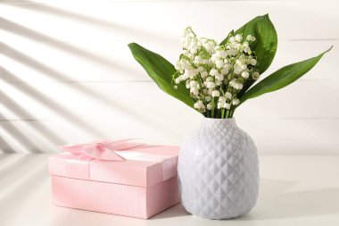 Vadi çiçeklerinin güzel zambakları ve beyaz masada hediyeler.