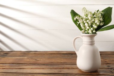 Vadi çiçeklerinin güzel zambakları ahşap masadaki vazoda. Metin için boşluk
