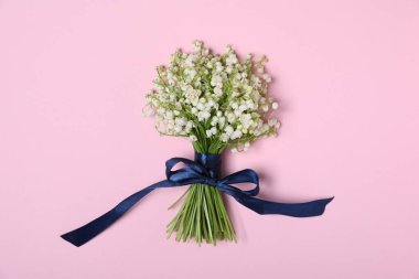 Açık pembe arka planda, vadideki güzel zambak çiçekleri.