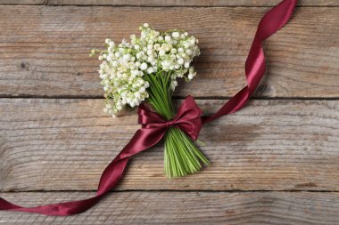 Ahşap arka planda, vadideki güzel zambak demeti.