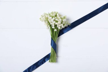 Beyaz ahşap arka planda, vadideki güzel zambak demeti.