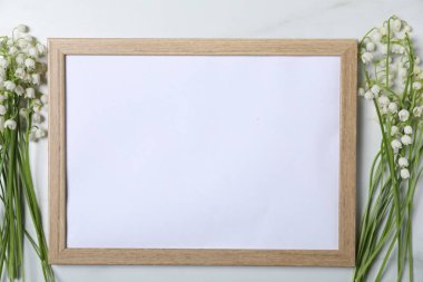 Vadideki güzel zambak çiçekleri ve beyaz mermer arka planda boş bir çerçeve. Metin için boşluk