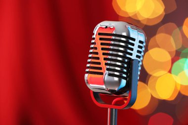 Kırmızı perdeye karşı bir klasik mikrofon, mesaj için yer. Bokeh etkisi