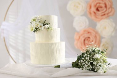 Çiçekli düğün pastası ve kapalı masa desenli lezzetli bir pasta.