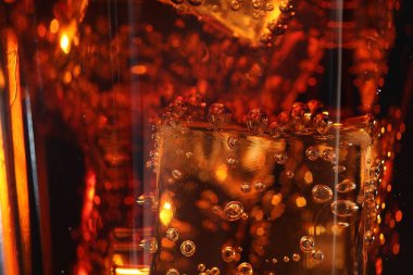 Arkaplan olarak buz küpleriyle kola tazeleniyor, makro görünüm