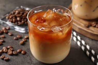 Gri masada lezzetli buzlu kahve ve fasulye, yakın plan.