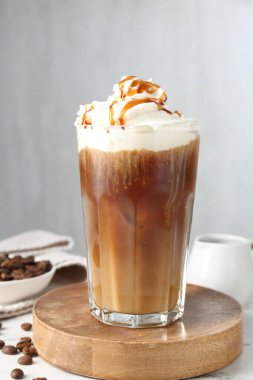 Krem şantili, şuruplu ve beyaz masada fasulyeli lezzetli buzlu kahve.