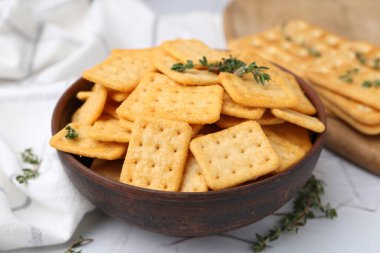 Lezzetli tuzlu krakerler ve kekik beyaz masada, yakın plan.