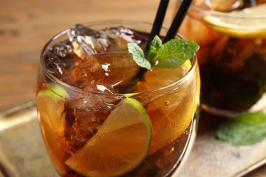 Küba libre kokteylini ahşap masada nane şekeri ile tazeliyorum.