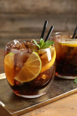 Küba libre kokteylini ahşap masada nane şekeri ile tazeliyorum.