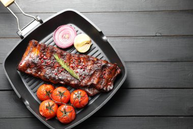 Biberiyeli domuz pirzolası, domates ve soğan. Gri ahşap masa, üst manzara. Metin için boşluk