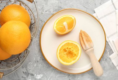 Tahta sıkacağı ve gri masada taze portakallar.