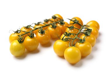 Beyaz üzerinde sarı kiraz domatesli dallar.