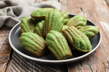 Lezzetli Matcha Madeleine kekleri ahşap masada, yakın plan.