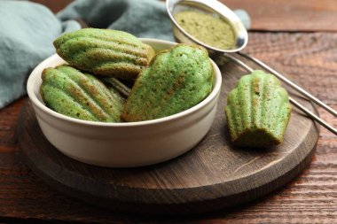 Lezzetli Matcha Madeleine kekleri ahşap masada, yakın plan.