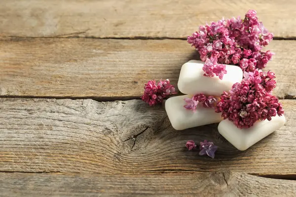 Sabun çubukları ve ahşap masadaki leylak çiçekleri. Metin için boşluk