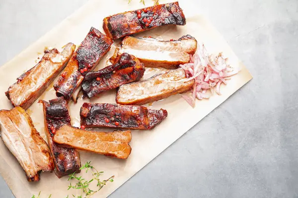 Lezzetli domuz pirzolası, kekik ve soğanlı gri desenli masa, üst manzara. Metin için boşluk