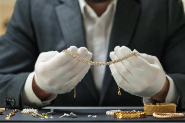 Kapalı bir masada lüks takılarla çalışan bir eksper.