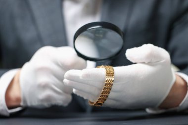 Masadaki lüks kol saatini değerlendiren eksper, yakın plan.