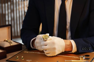 Masada lüks kol saatiyle çalışan bir eksper, yakın plan.