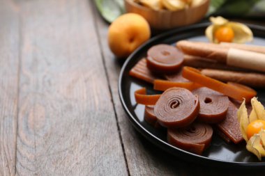 Lezzetli meyve derisi, bitki kökü ve kayısılar ahşap masada, yakın plan. Metin için boşluk