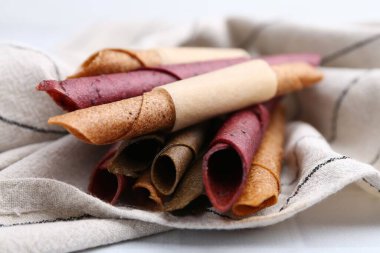 Lezzetli meyve ruloları beyaz fayanslı masada, yakın plan.