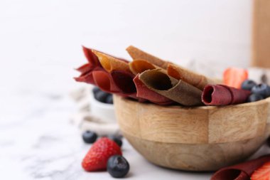 Lezzetli meyve dürümleri ve beyaz mermer masada meyveler, yakın plan.