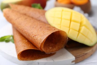 Lezzetli meyve dürümleri, nane ve mango masada, yakın plan.