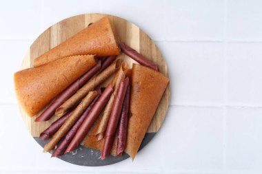 Beyaz fayanslı masada nefis meyve dürümleri, üst manzara. Metin için boşluk