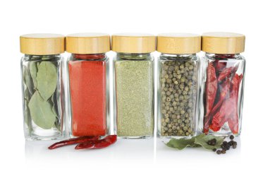 Beyaz kavanozlardaki farklı aromatik baharatlar.