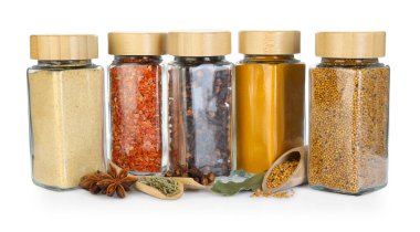 Beyaz kavanozlardaki farklı aromatik baharatlar.
