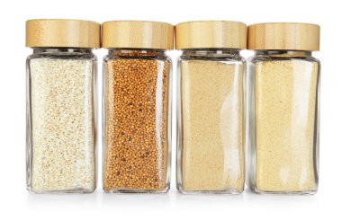 Beyaz kavanozlardaki farklı aromatik baharatlar.