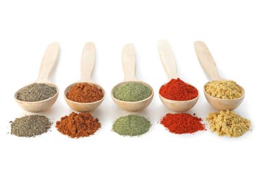 Beyaz kaşıklardaki farklı aromatik baharatlar.