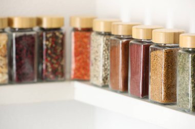 Farklı aromatik baharatlar. Kapalı alandaki beyaz raflarda, yakın çekimde. Metin için boşluk