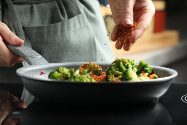 Mutfağa baharat ekleyen kadın, yakın plan.