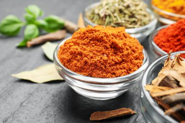 Gri masada farklı aromatik baharatlar, yakın plan.