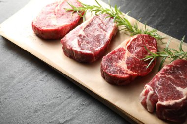 Siyah masada çiğ et ve biberiye parçaları, yakın plan.