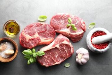 Çiğ et parçaları ve baharatlar gri masada, düz yatıyordu.