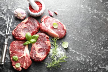 Çiğ et, baharat ve çatal. Koyu masada, düz yerde. Metin için boşluk